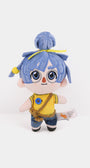 A plush may from It takes two  with blue hair in a bun, wearing a yellow shirt and blue pants, standing against a plain white background.